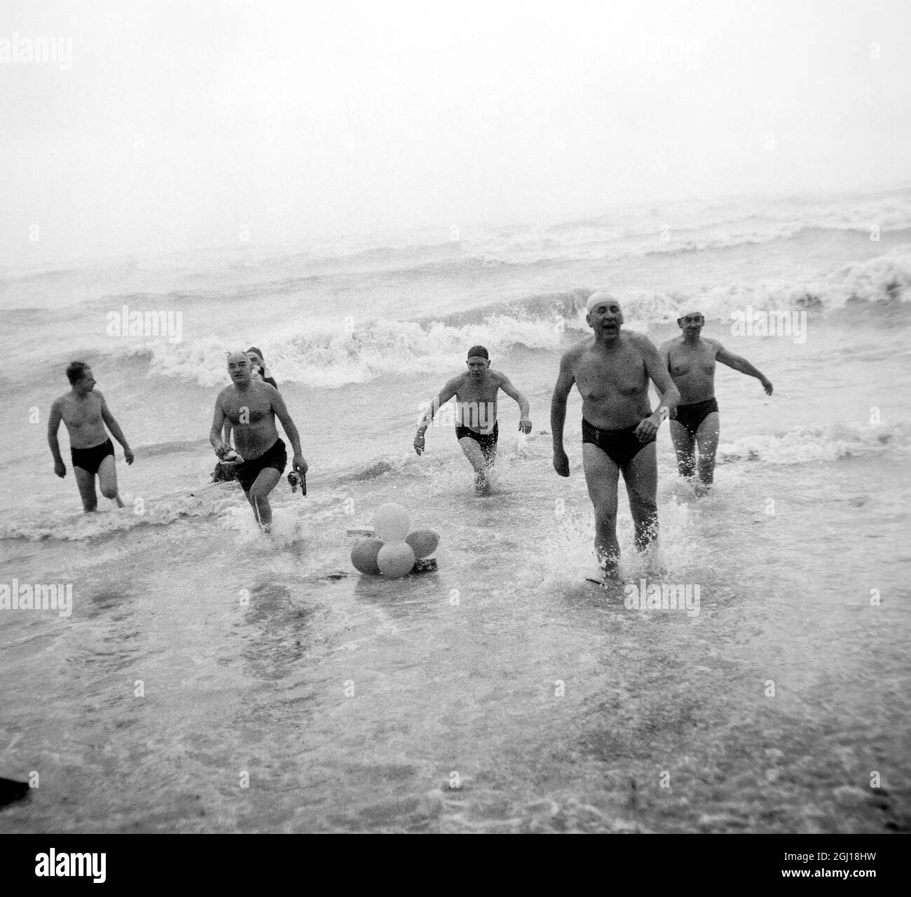 25 DECEMBER 1963 MEMBERS OF THE BRIGHTON SWIMMING CLUB EMERGE FROM THE SEA AFTER THE ANNUAL CHRISTMAS MORNING DIP, SUSSEX , ENGLAND. Stock Photo