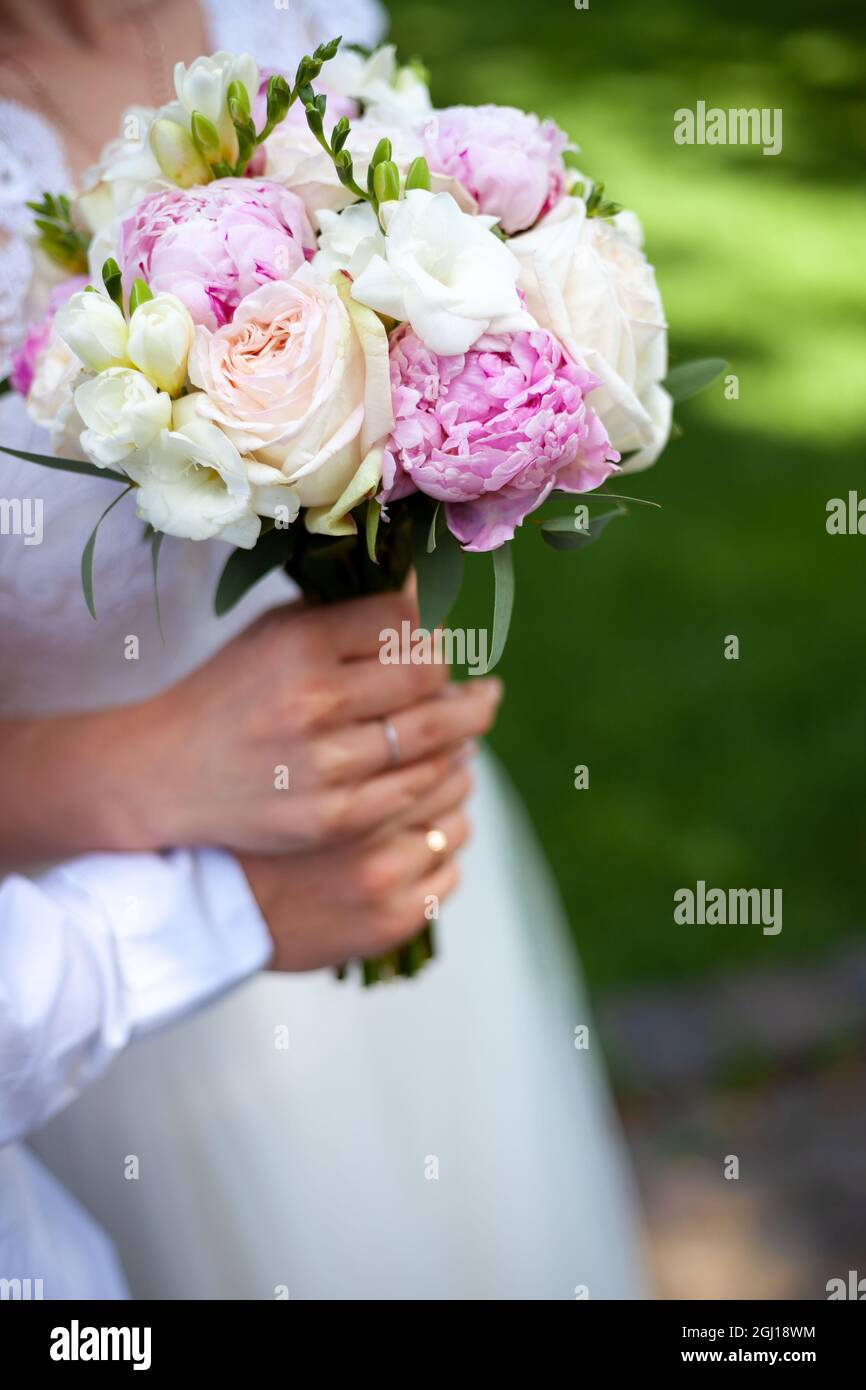Bridal bouquet of peonies and roses. Hold wedding flowers in your hands ...