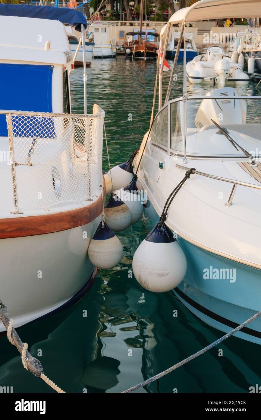 Buoys between boats in ocean coast in marina dock. Summer vacation and yachting. Stock Photo