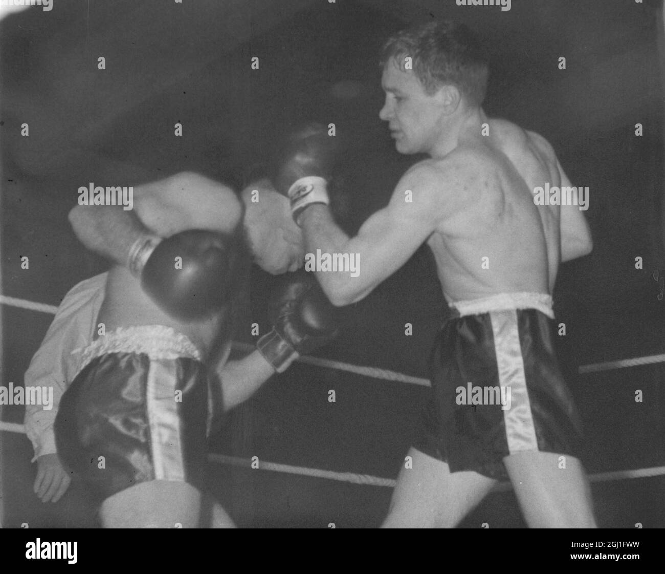 British lightweight champion Dave Charnley (right) hooks Tony Garcia ( France ) with his left during their scheduled 10 round fight at Stratham Ice Rink , London , but Charnley won in the fifth round when the referee stopped the contest . 11th March 1958 Stock Photo