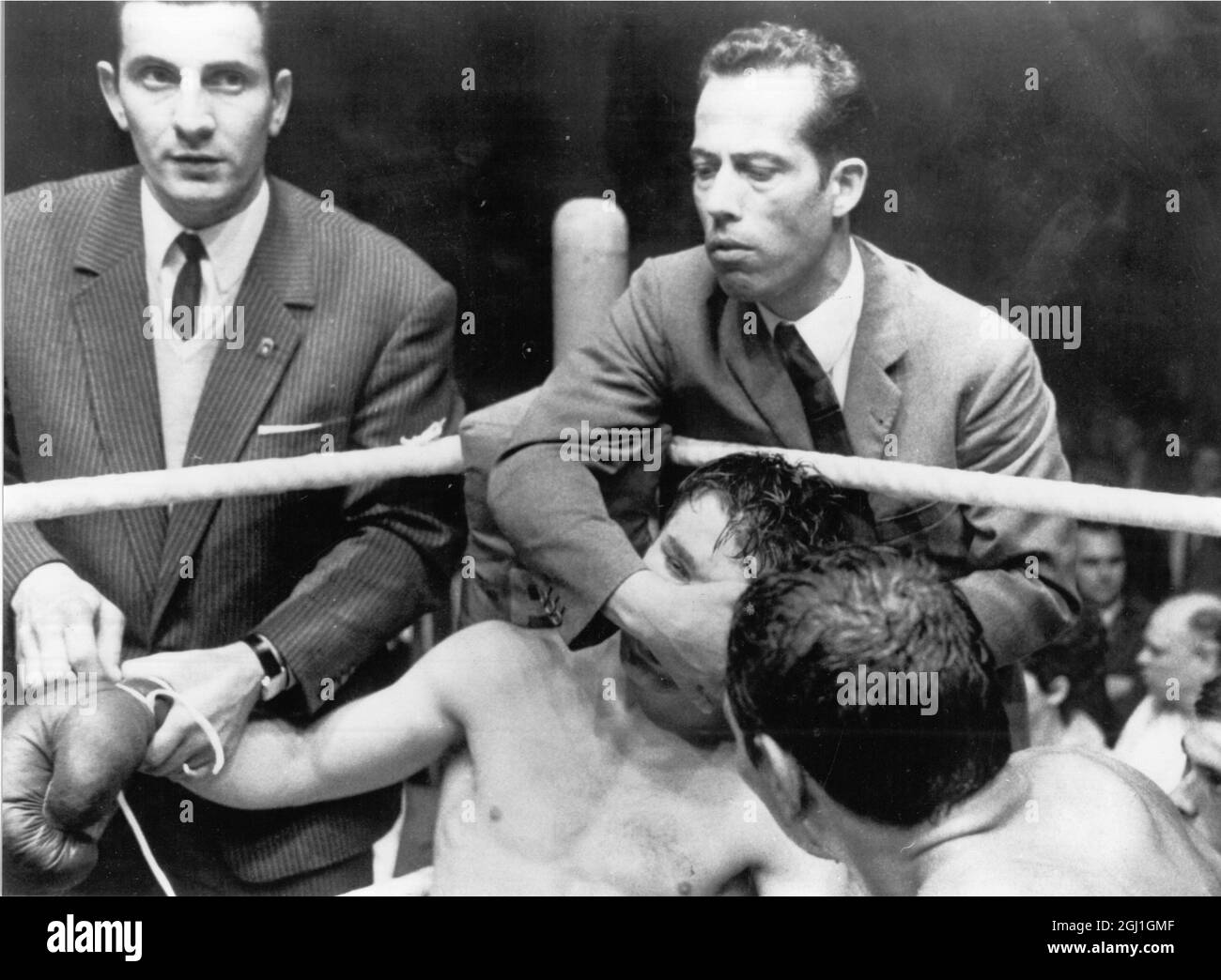 Cologne,Germany: European middleweight boxing champion Carlos Duran of Italy (right) looks on as challenger Jupp Elze of Germany gets treatment in his corner before being rushed to hospital for brain surgery.Duran had just been awarded the fight on a technical knock-out. 14 June 1968 Stock Photo