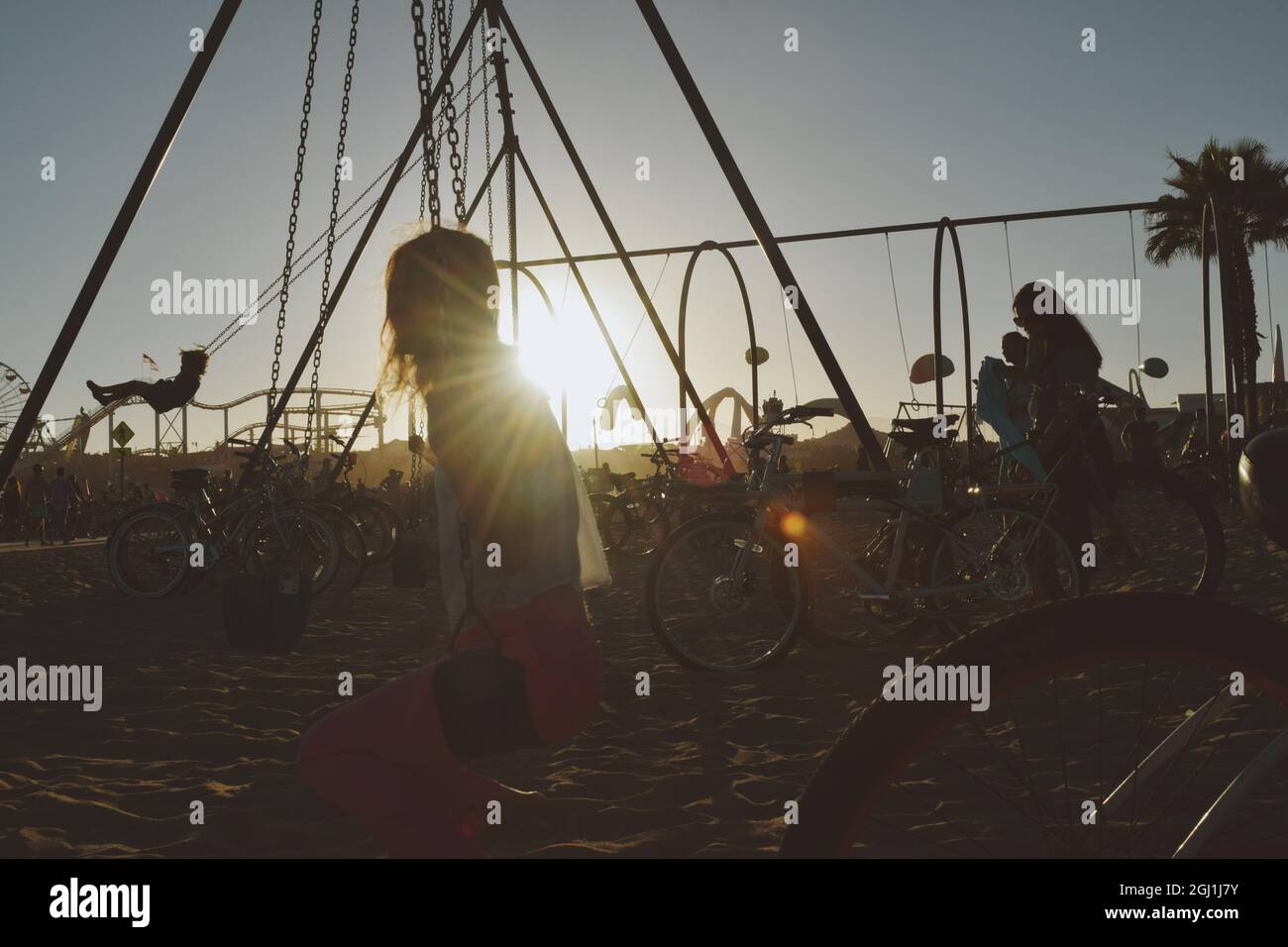 A silhouette of a woman on the swings at sunset, Muscle Beach Santa Monica, USA Stock Photo