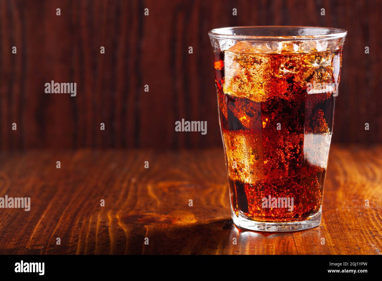 glass of cold cola soft drink with ice on wooden background Stock Photo ...