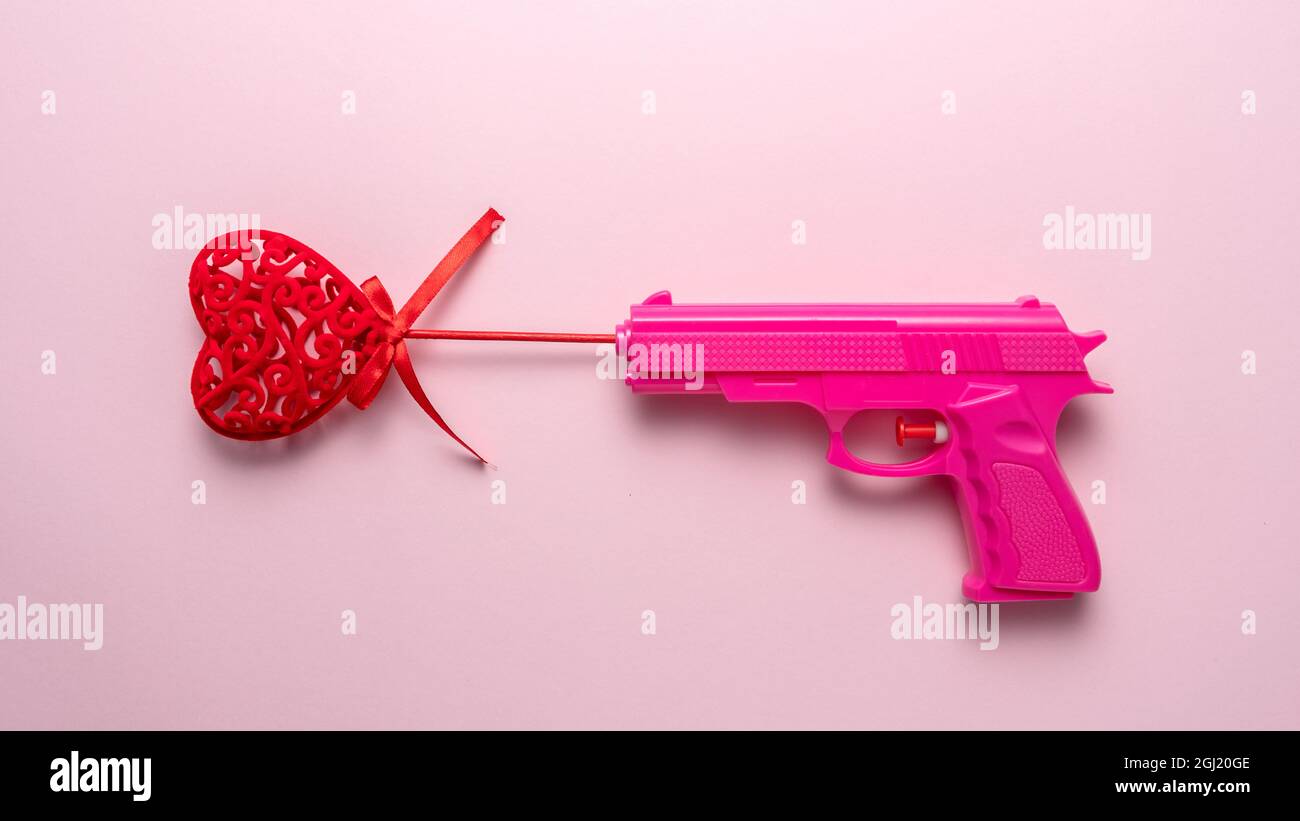 Red heart with Pink gun on pink pastel background. Minimal love concept  Stock Photo - Alamy