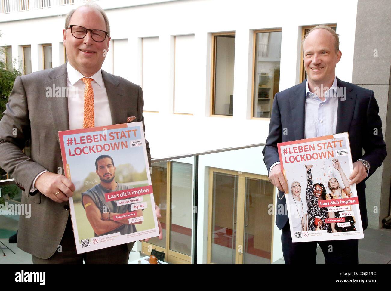 Berlin, Germany. 08th Sep, 2021. Stefan Genth (r), Managing Director, German Retail Association (HDE), and Patrick Zahn, Managing Director, KiK Textilien und Non-Food GmbH, hold posters at the beginning of a press conference on the Corona vaccination campaign. Credit: Wolfgang Kumm/dpa/Alamy Live News Stock Photo