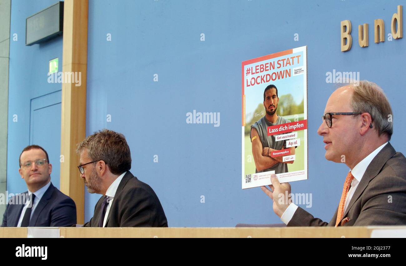 Berlin, Germany. 08th Sep, 2021. Stefan Genth, Managing Director, German Retail Association (HDE), holds up a poster during the Federal Press Conference on the Corona vaccination campaign. On the left, Jens Spahn (CDU), Federal Minister of Health, observes the scene. Credit: Wolfgang Kumm/dpa/Alamy Live News Stock Photo