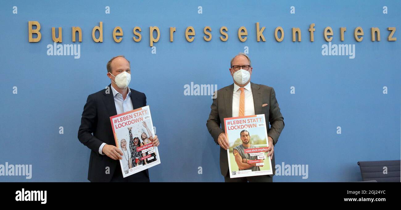 Berlin, Germany. 08th Sep, 2021. Further developments in the Corona pandemic Stefan Genth (r), Chief Executive, German Retail Association (HDE), and Patrick Zahn, Managing Director, KiK Textilien und Non-Food GmbH, hold posters at the start of a press conference on the Corona vaccination campaign. Credit: Wolfgang Kumm/dpa/Alamy Live News Stock Photo
