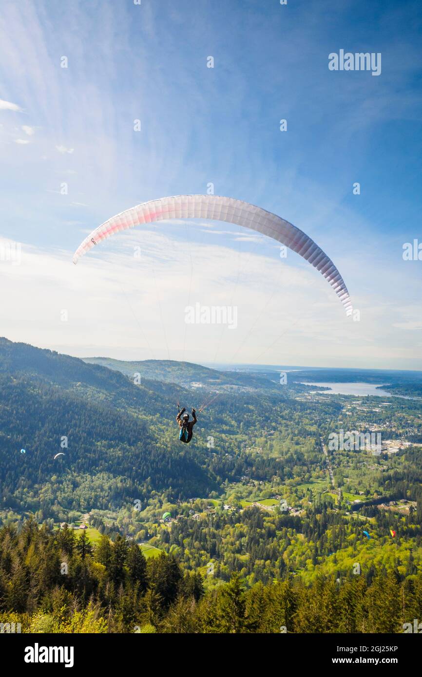 USA, Washington State, Issaquah. Paragliders launch from Tiger Mountain and soar westward towards Issaquah. Stock Photo