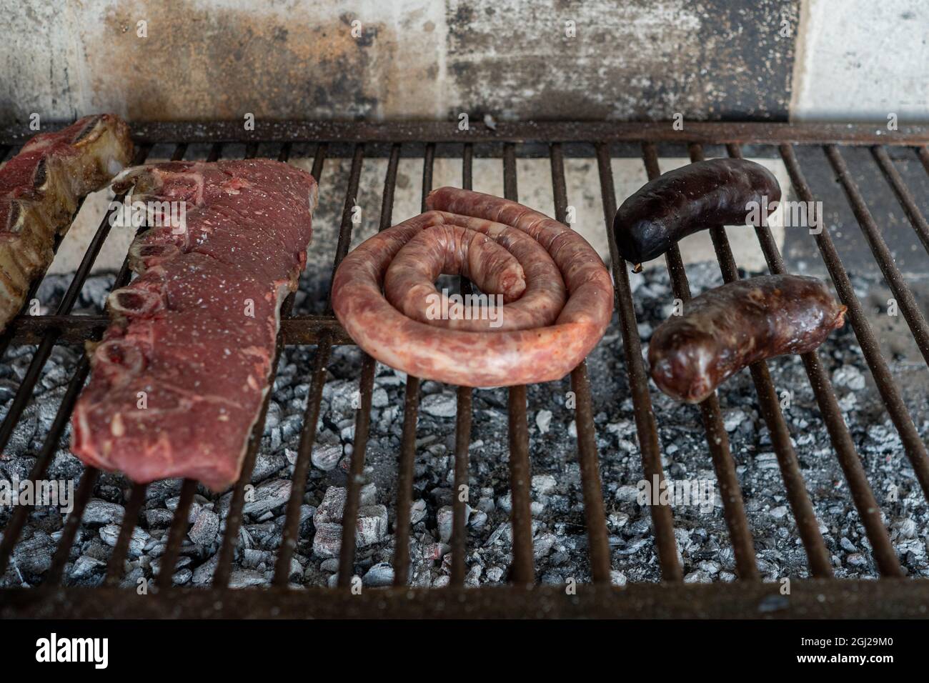 Cook preparing a typical Argentinian Asado with beef and sausage Stock