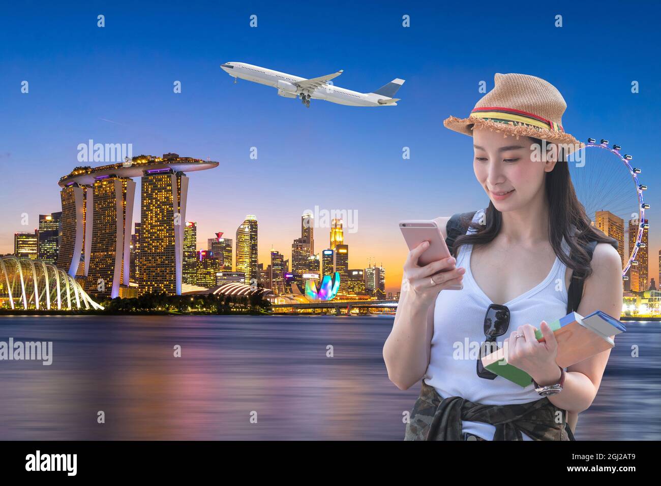 Beautiful asian woman smiling and booking an air ticket to travel to Singapore. Stock Photo