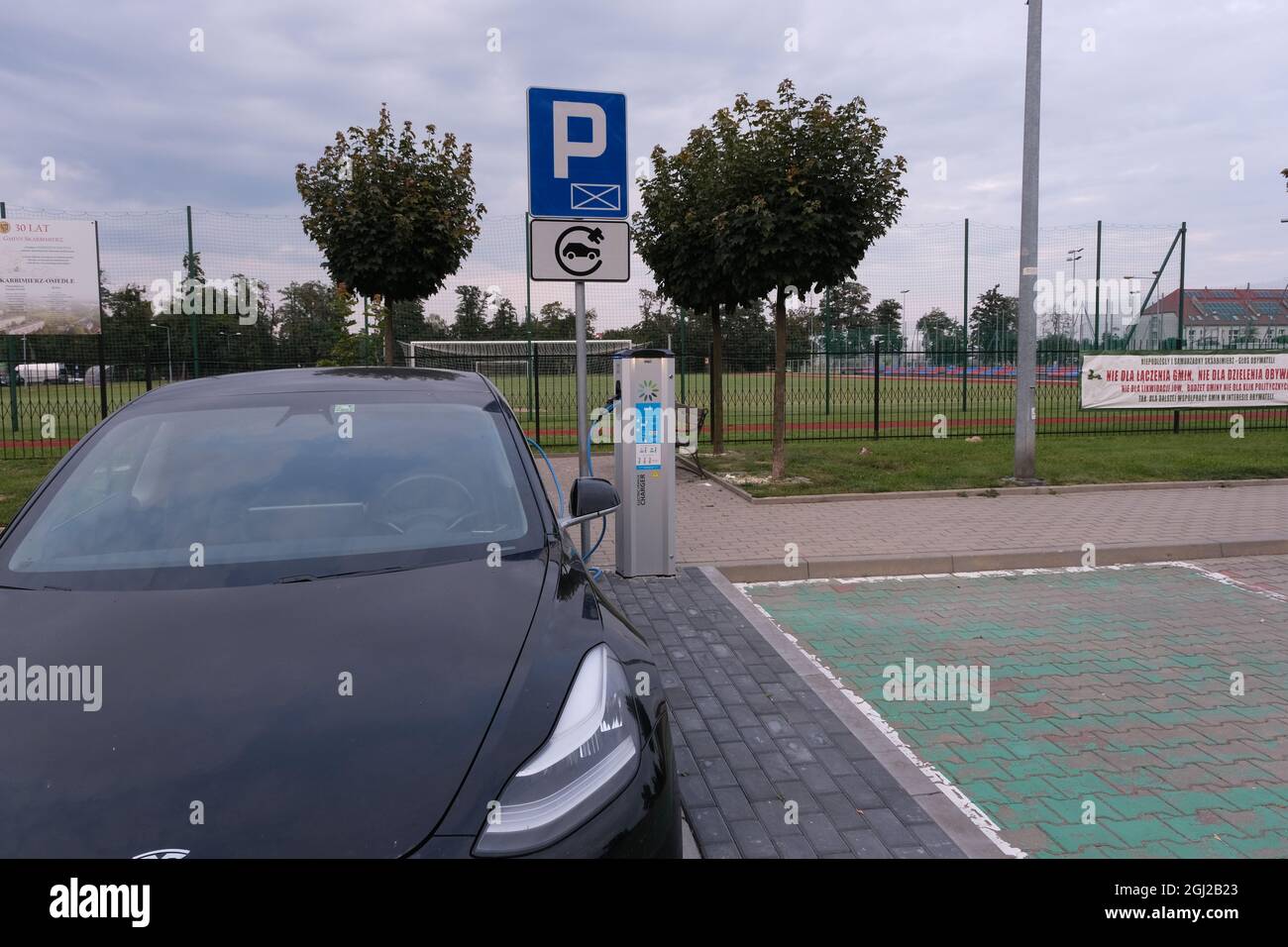 Skarbimierz Osiedle, Poland - August 21, 2021:  A static shot of a solid black Tesla Model 3 dual motor charging at the EVPlus AC charging station Stock Photo