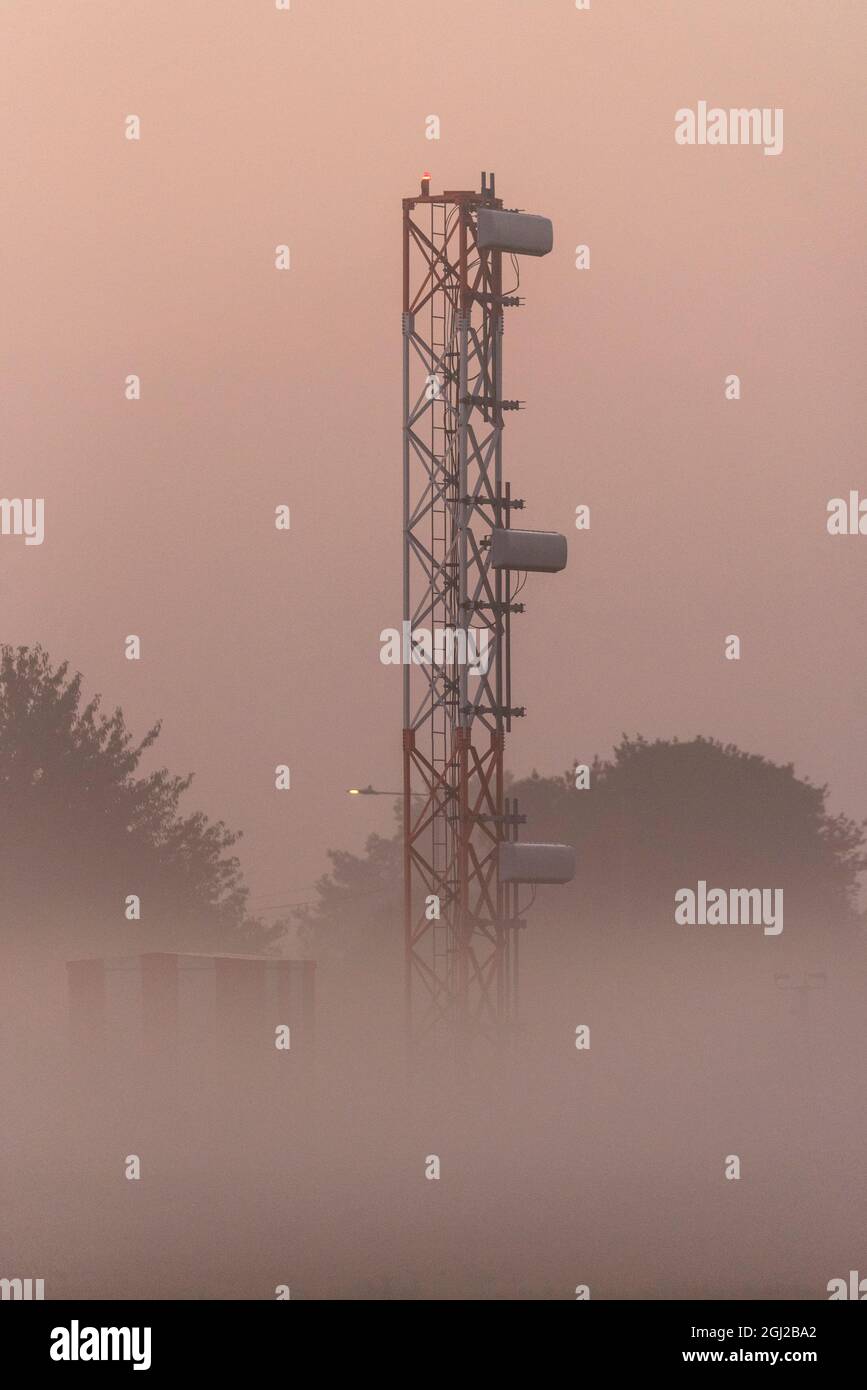 ILS Glide slope tower, instrument landing system at London Southend Airport, Essex, UK, early in the morning with low lying mist at sunrise. Bad viz Stock Photo
