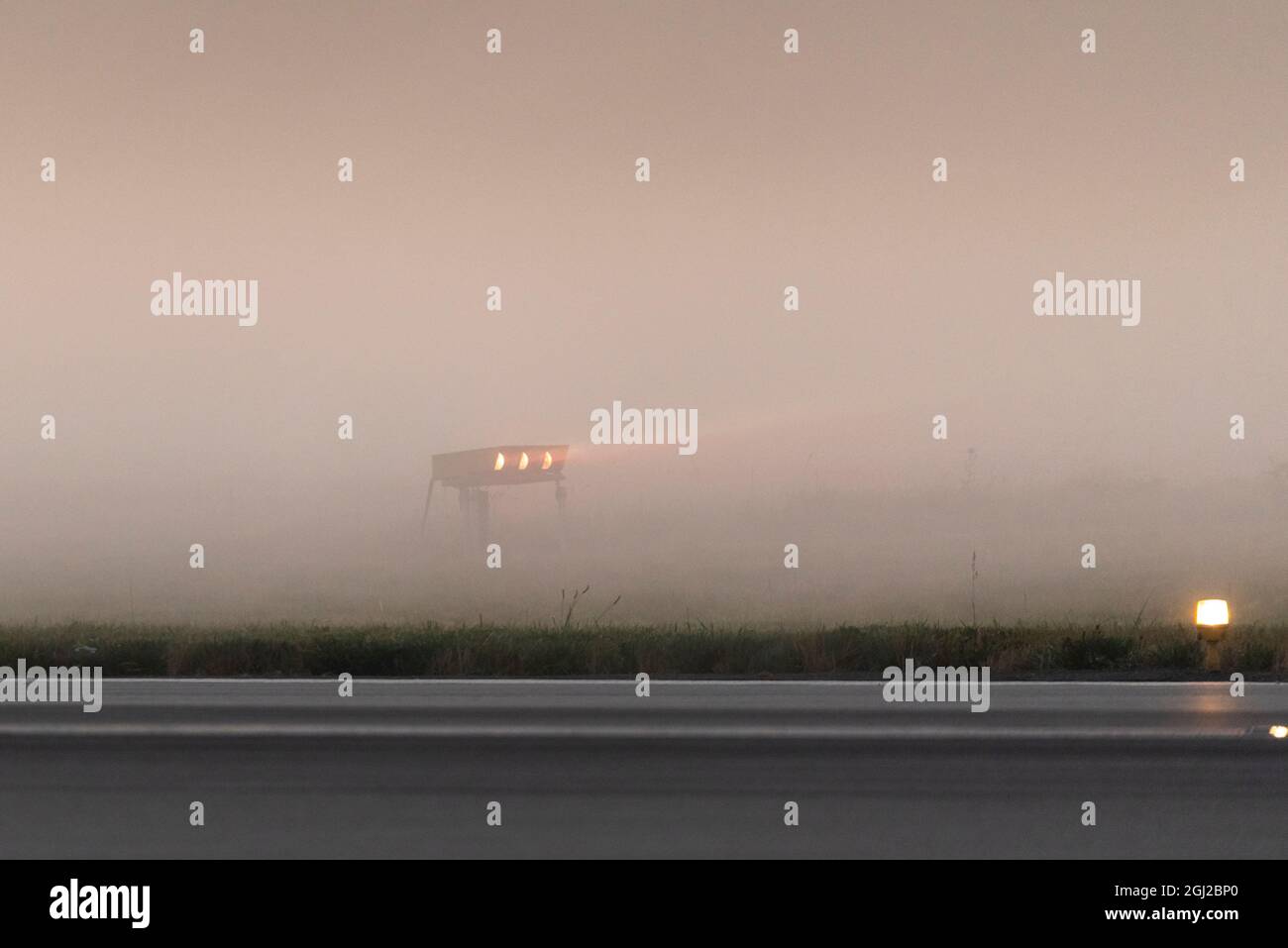 Precision approach path indicator (PAPI) at London Southend Airport, Essex, UK, early in the morning with low lying mist at sunrise. Enveloped in fog Stock Photo