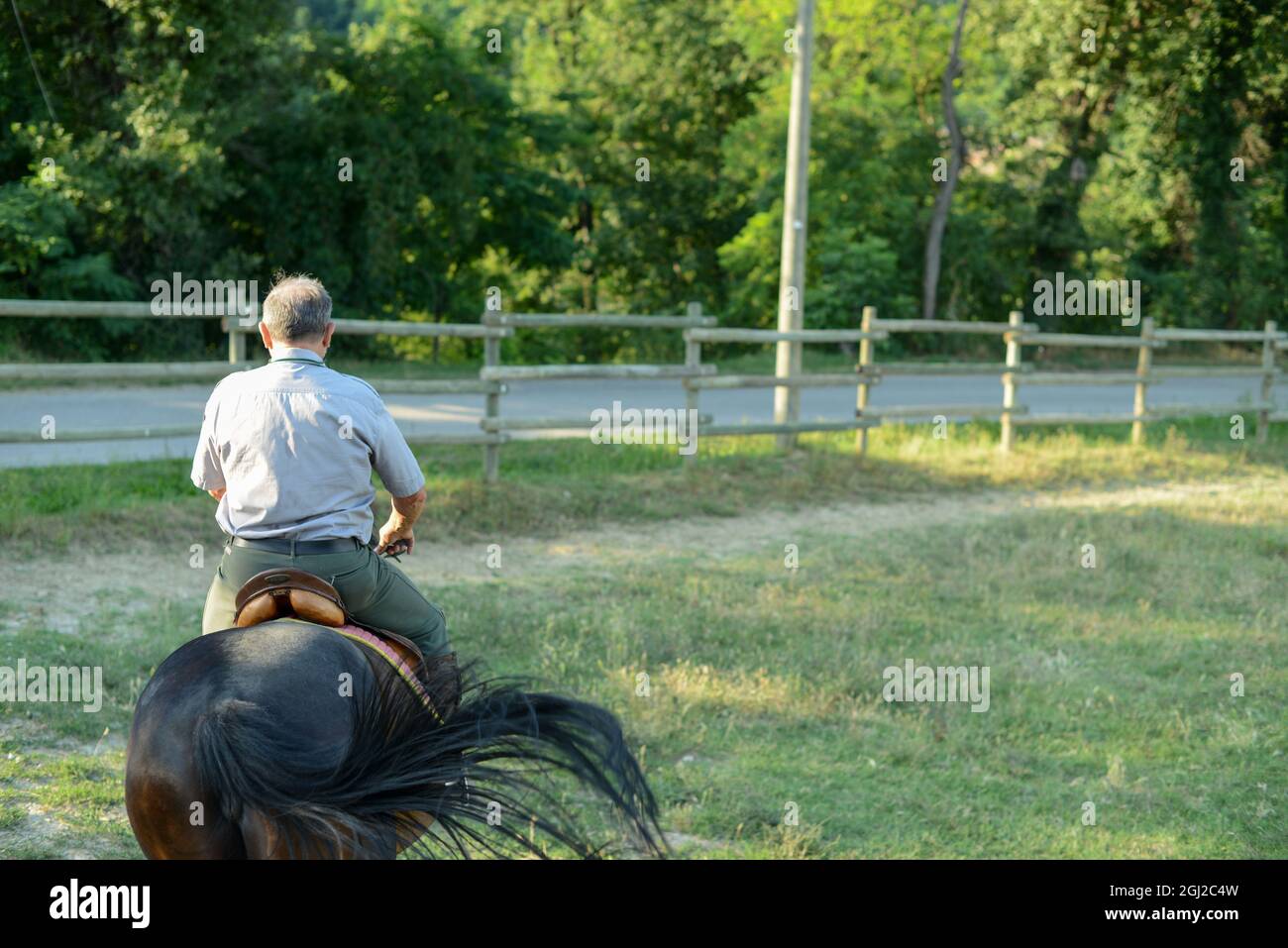 Back view of a male riding a horse Stock Photo - Alamy
