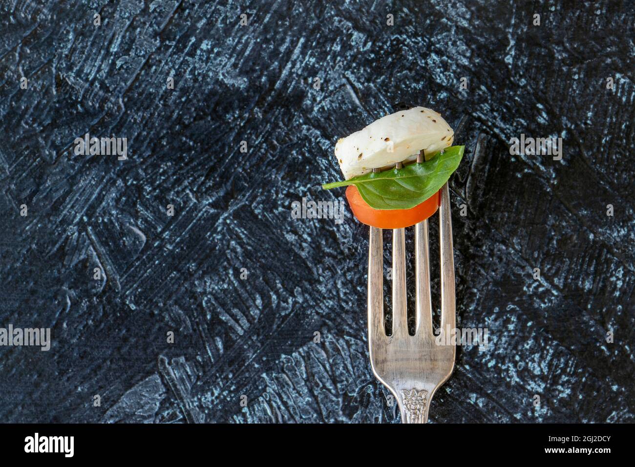 flat lay forks with caprese salad. slice of juicy red tomato, with ...