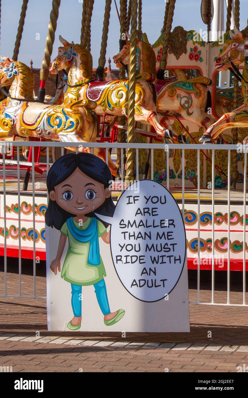 Height requirement for children to ride unaccompanied on Fairground gallopers roundabout in Southport, UK Stock Photo