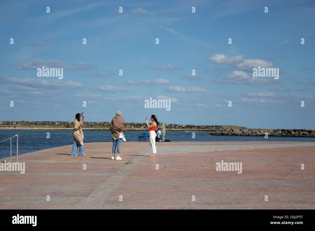 Group of young girls taking each other's photographs to upload on social media. Mixed ethnic group girls. Stock Photo