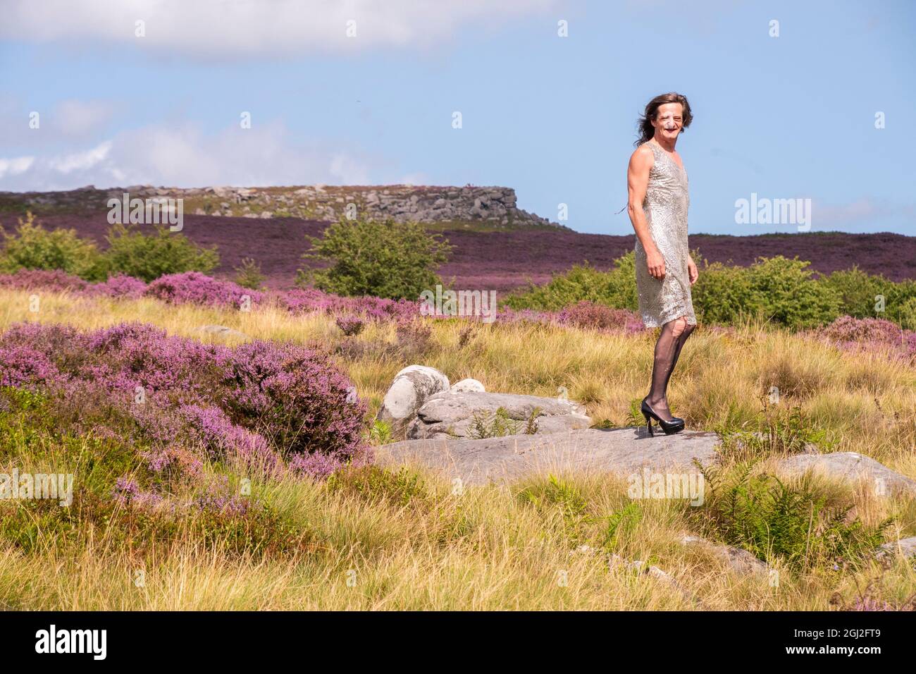 Derbyshire UK – 20 Aug 2020: Simon wearing a silver sparkling dress and high heels at Longshaw Estate, Peak District Stock Photo