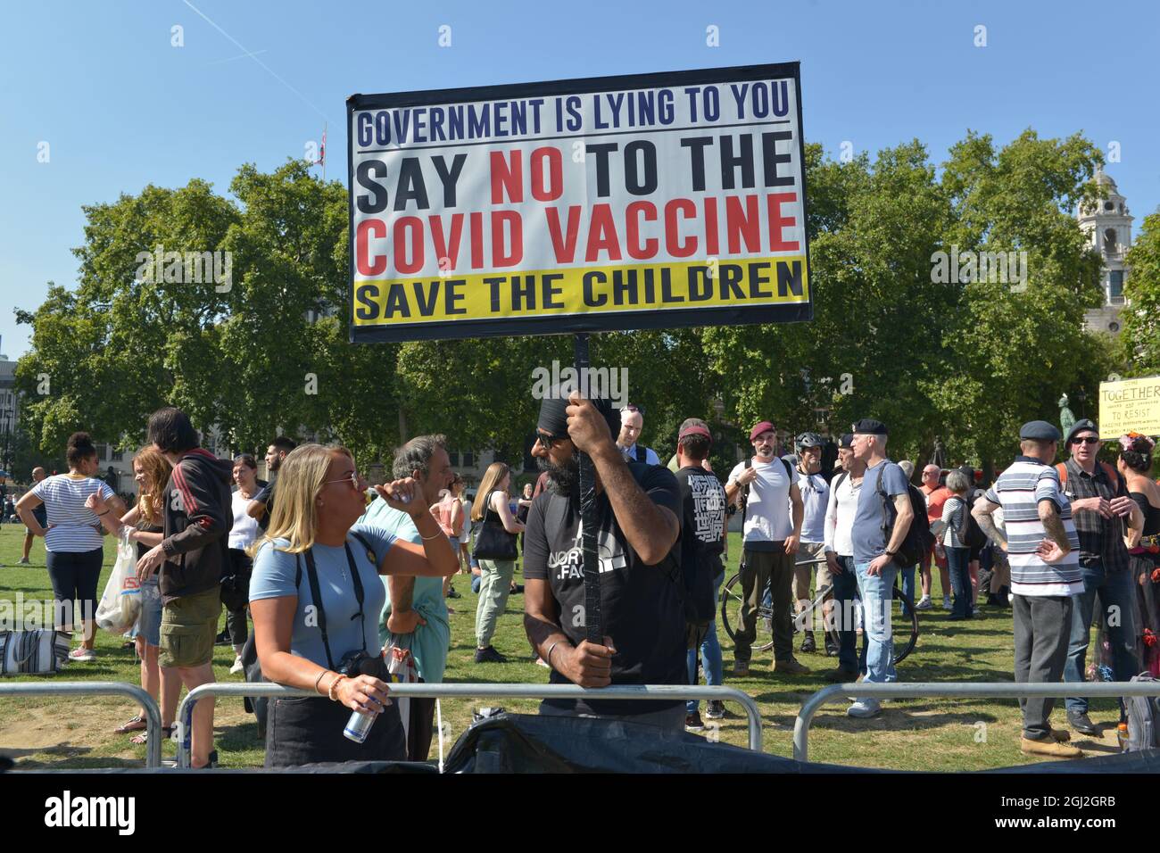 Anti-government rally in London. A small group of conspiracy theorists and anti- government activists gathered at Parliament Square to oppose UK Covid restrictions, vaccinations and Covid vaccination passports. Stock Photo