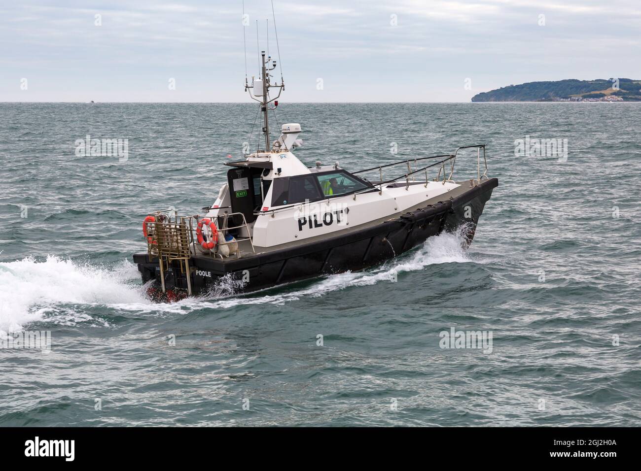 Pilot boat Barracuda greets ship entering Poole Harbour, Poole, Dorset UK in August Stock Photo