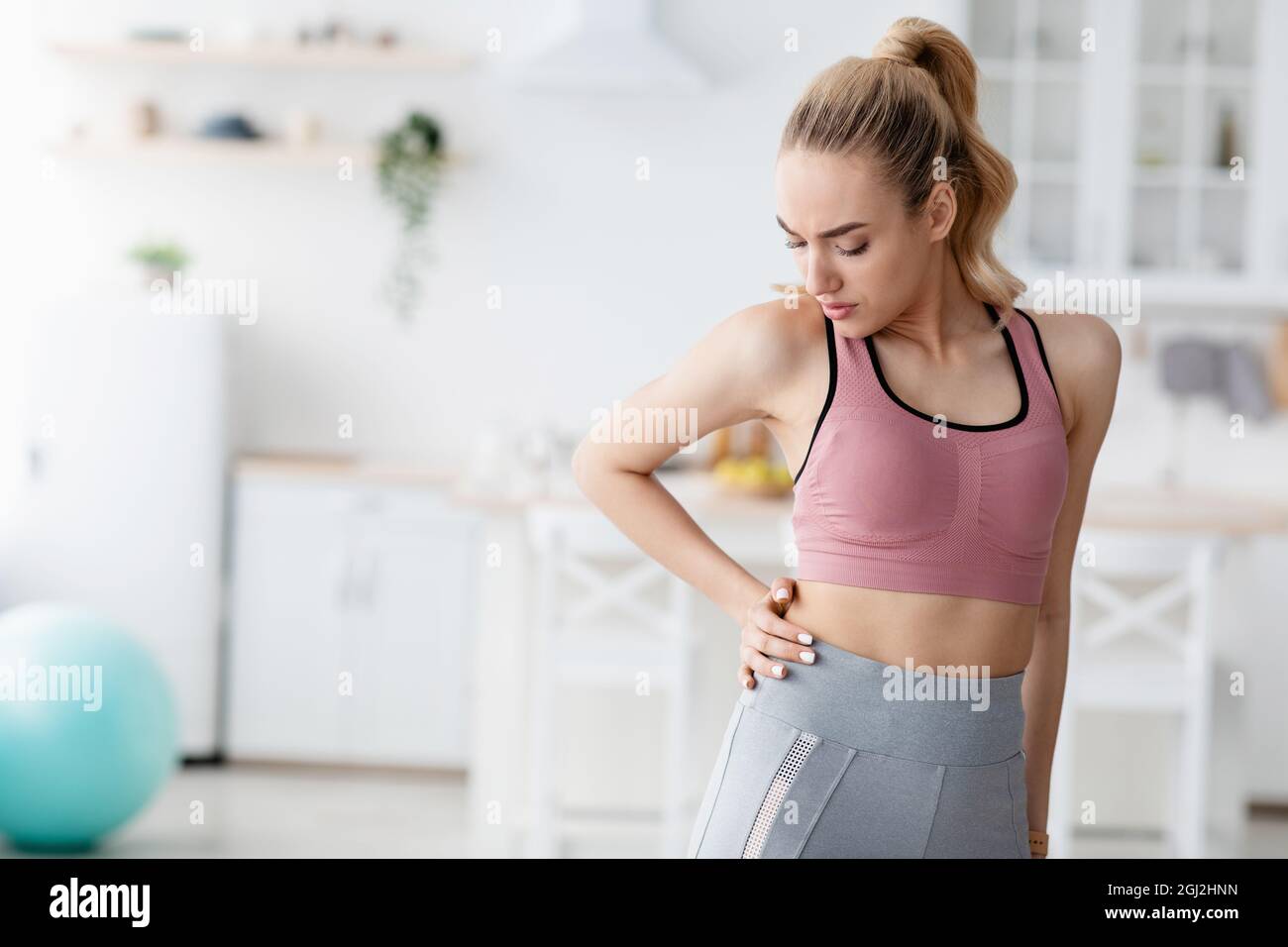 Unhappy european pretty millennial blonde woman suffering from injury and  muscle pain in her side after workout at home. Danger of exercise without  co Stock Photo - Alamy