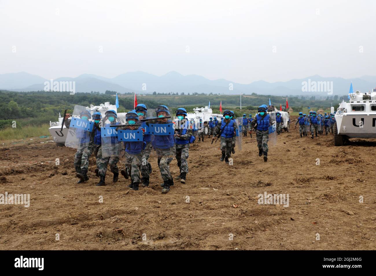 (210908) -- ZHENGZHOU, Sept. 8, 2021 (Xinhua) -- Peacekeepers participate in an international peacekeeping drill at a combined-arms tactical training base of the Chinese People's Liberation Army (PLA) in central China's Henan Province, Sept. 7, 2021. China started holding an international peacekeeping drill code-named 'Shared Destiny-2021' on Sept. 6. Drills of battlefield reconnaissance, security guarding and patrol, armed escort, protection of civilians, response to violent and terrorist attacks, construction of temporary operation base, battlefield first aid, and pandemic control are expe Stock Photo