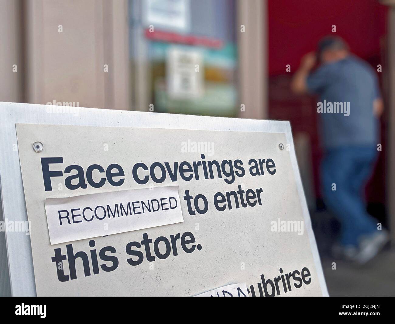 Masks are optional in Texas, sign posted at entrance to retail store pasted over the 'required' and put 'recommended' over it. Wearing a protective maskis not required in Texas and is optional. Covid deaths are rising in Texas. Stock Photo