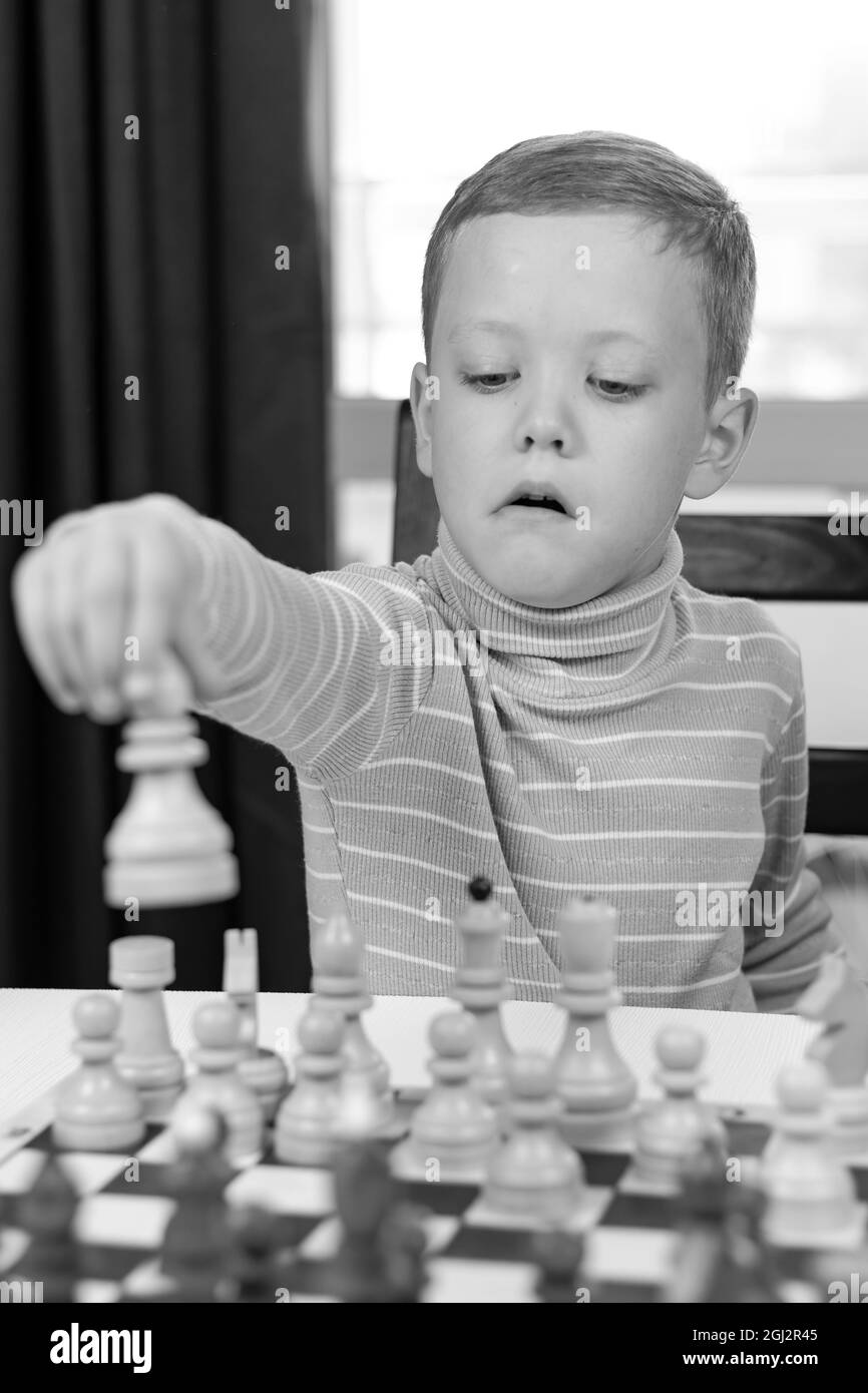 Premium Photo  Portrait of child during chess game boy plays chess and  thinks intently about the next move isolation on white background