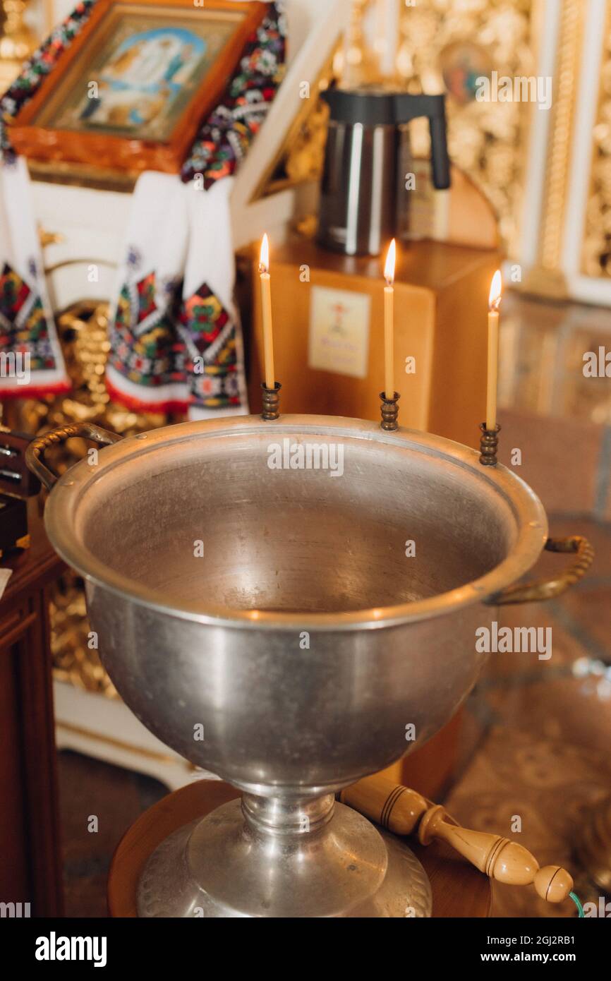 Burning candles on a baptismal font in the church Stock Photo Alamy