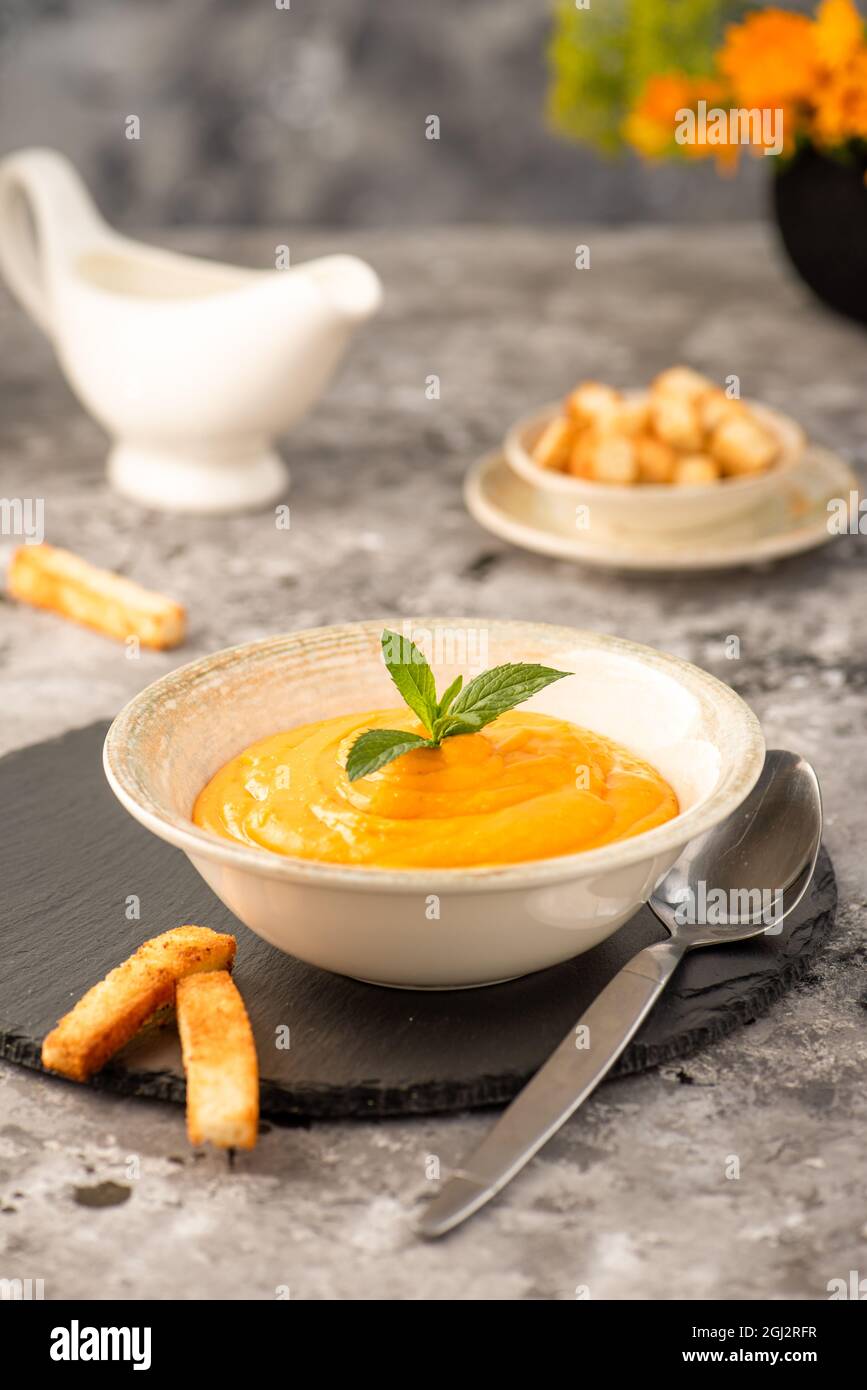 Creamy carrot and pumpkin purée, on a gray stone background. Selective focus. Stock Photo