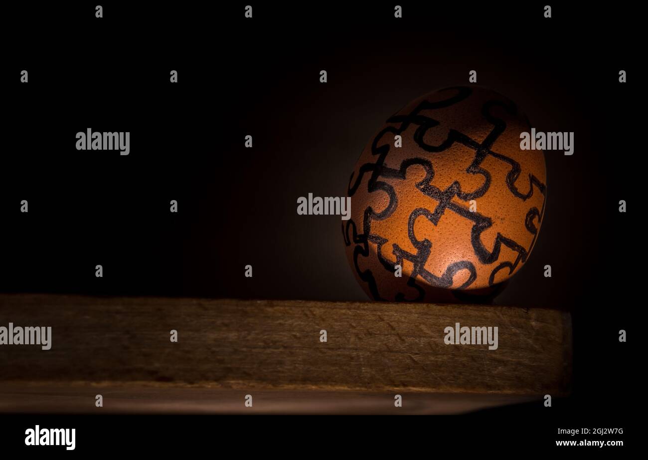 Egg with jigsaw design on the edge ,concept risk , danger or fragility . Stock Photo