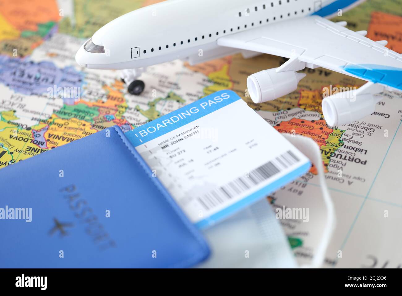 Passport plane ticket and toy plane stands on world map closeup Stock Photo