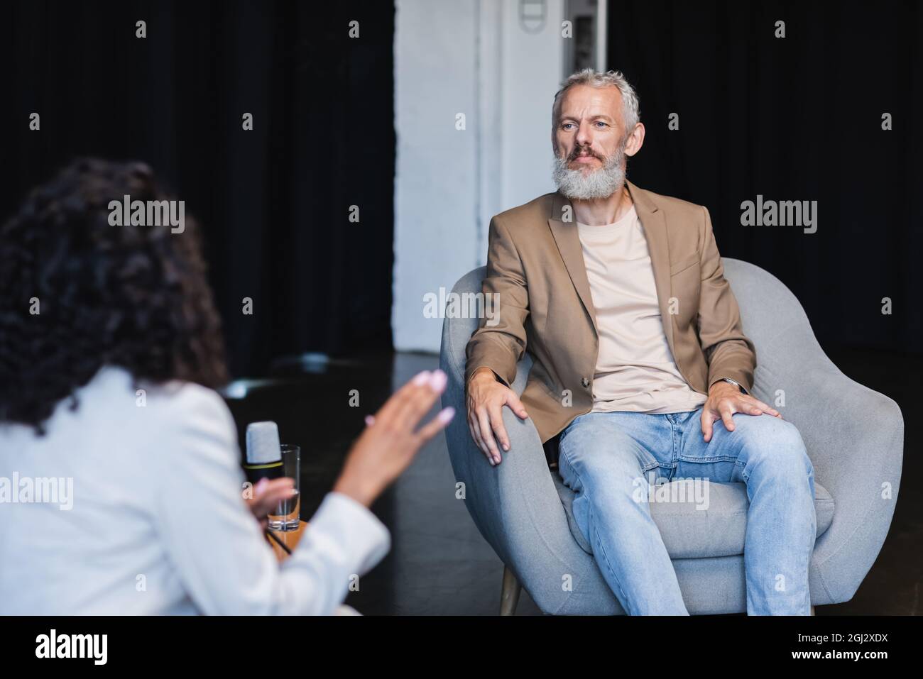 blurred african american journalist gesturing while talking with