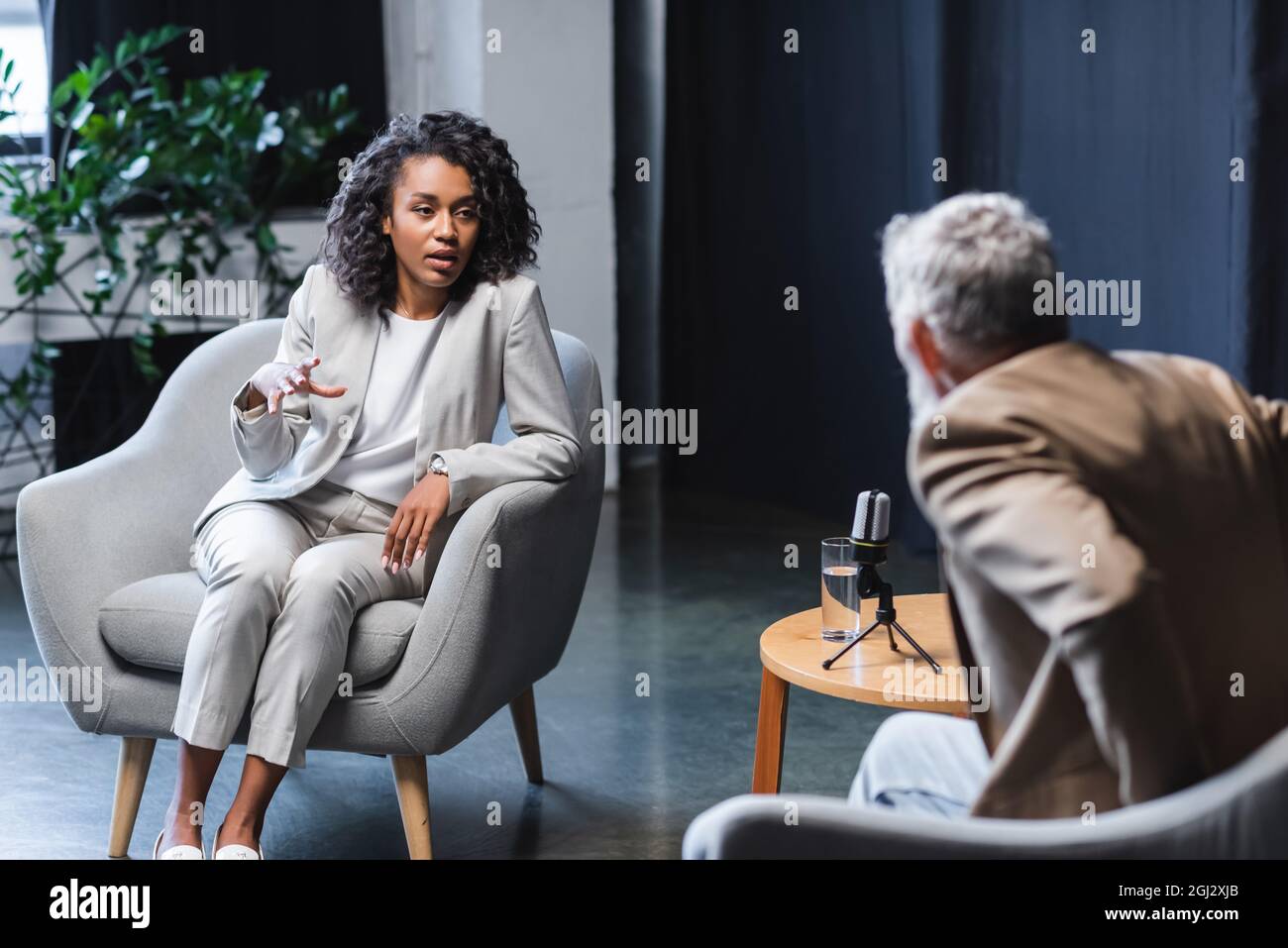 african american journalist gesturing while talking with blurred