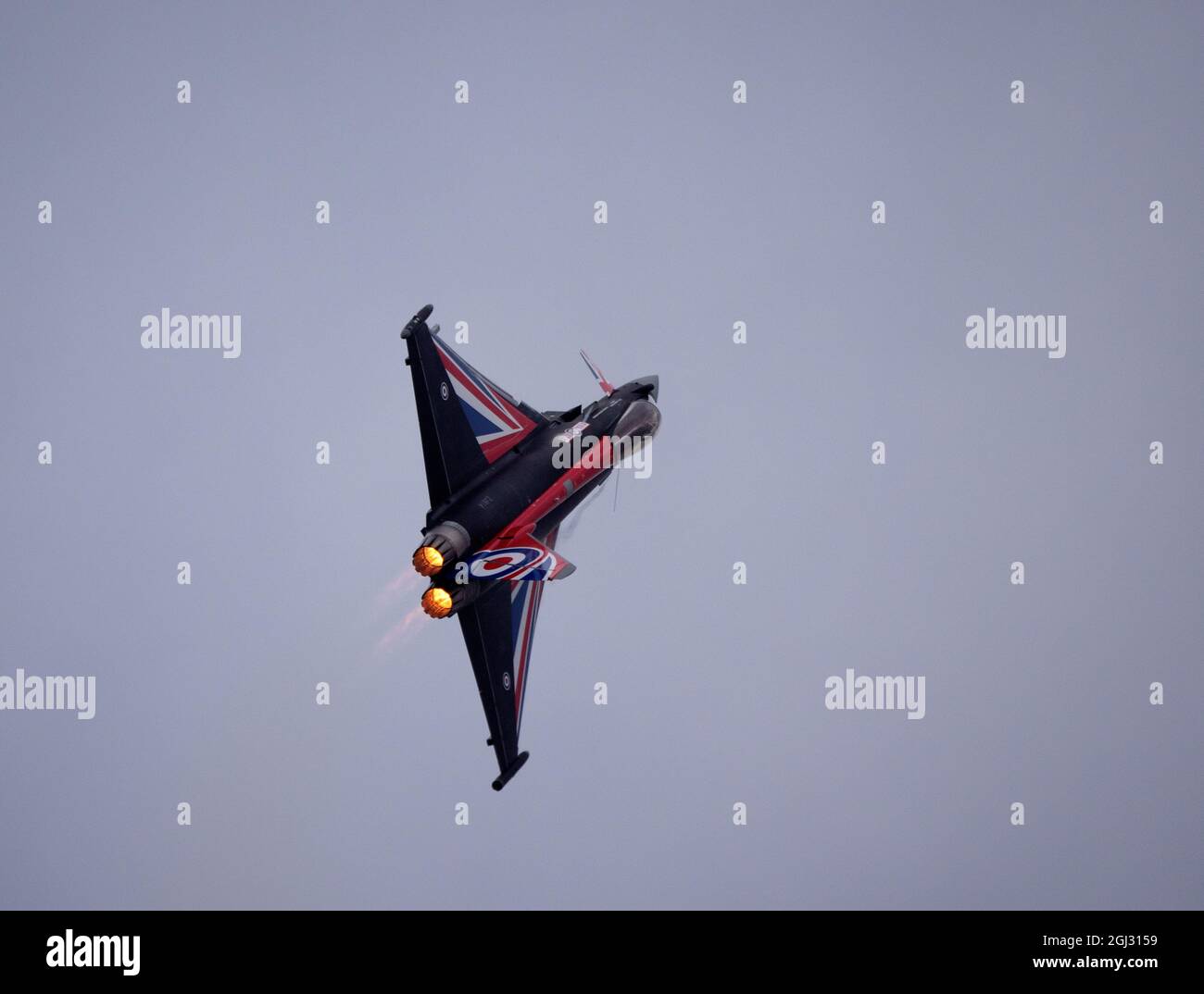 RAF BlackjackTyphoon fighther jet in flight, banked in a turn with afterburners on. Stock Photo