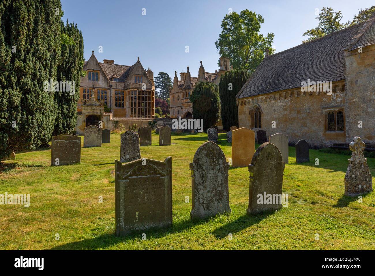 The graveyard of St Peter's church with Stanway House in the background