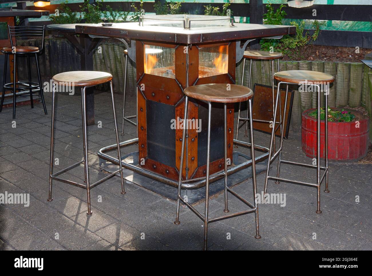 unique table, fire burning inside, square, bar, restaurant, high stools, Queenstown, New Zealand Stock Photo