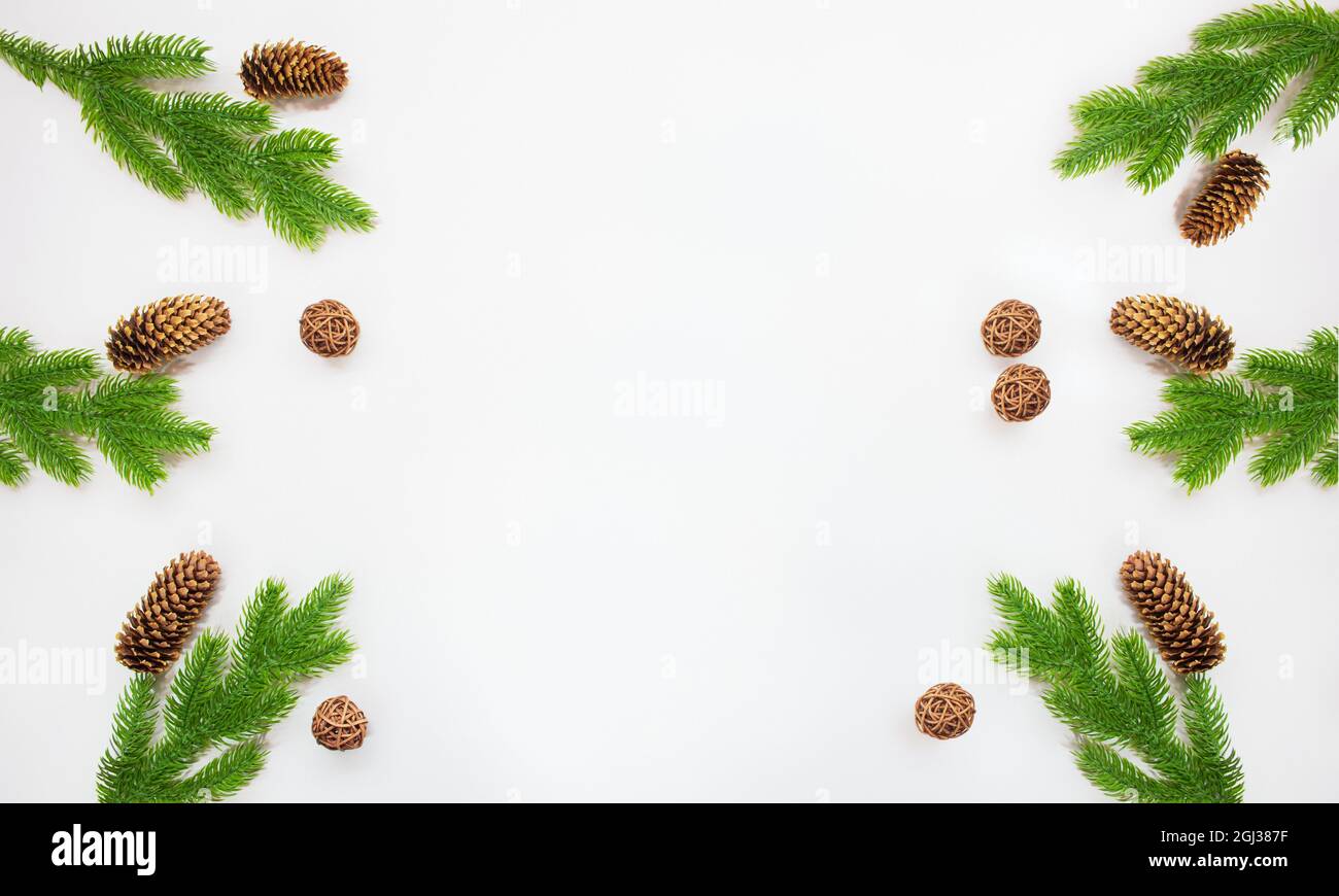 Fir branches with pine cones and braided balls on a white background ...