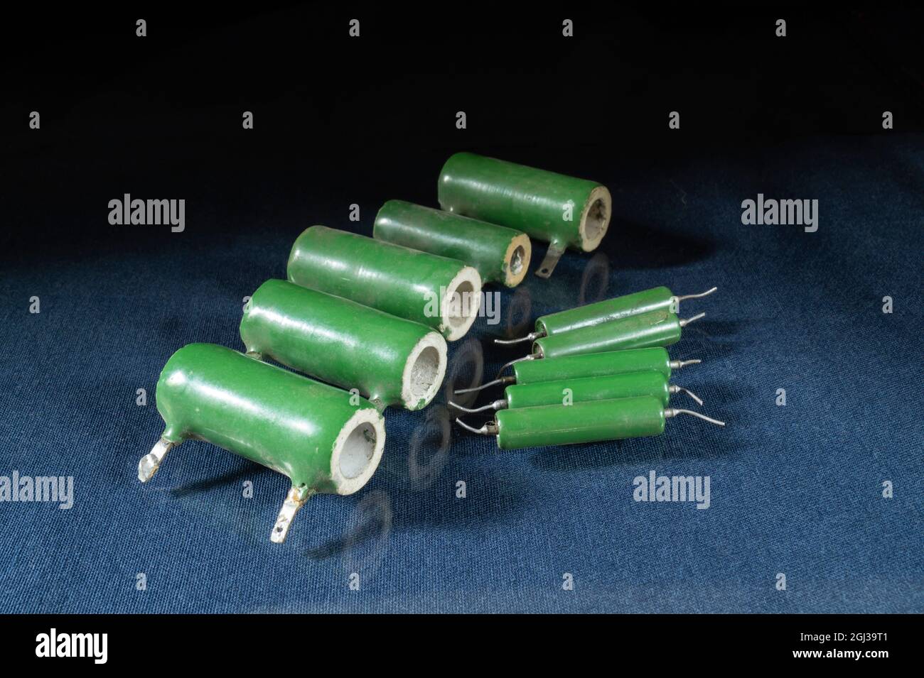 The green resistors are lying on the table with a reflection. Radio components on a black background Stock Photo