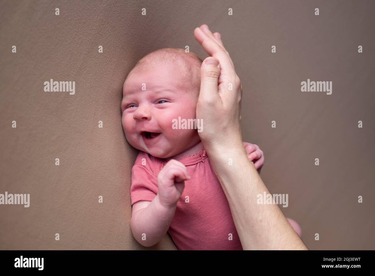Baby girl posing for her first portrait smiling. Stock Photo
