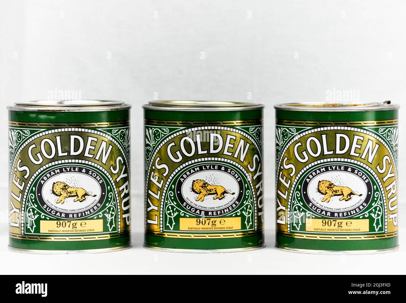 Trio of Lyles Golden Syrup tins arranged on a white background. Copy space is available in this image Stock Photo