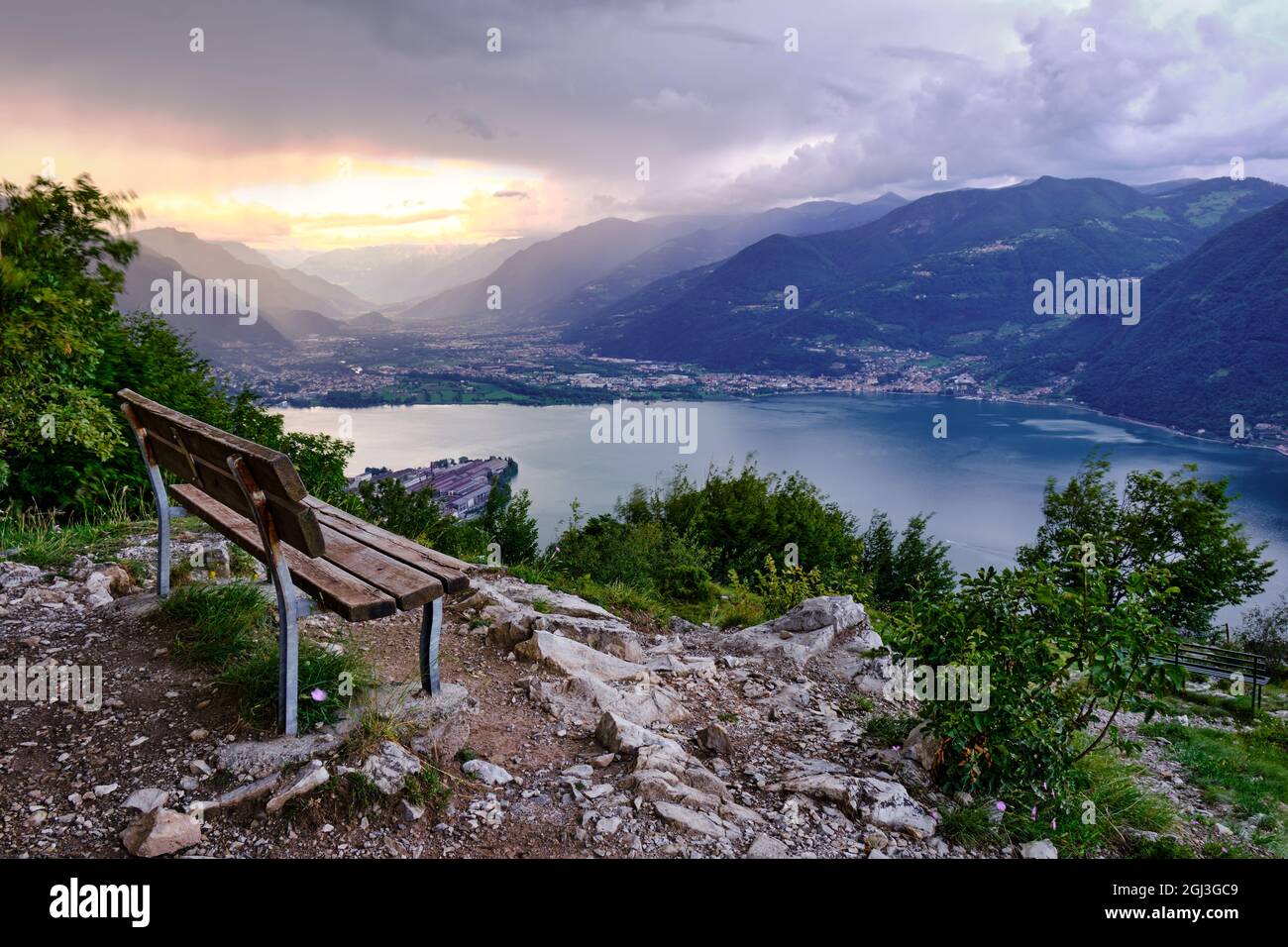 Sunset over the lake, the mountains and empty bench, Lake Iseo, Lombardy, Italy Stock Photo