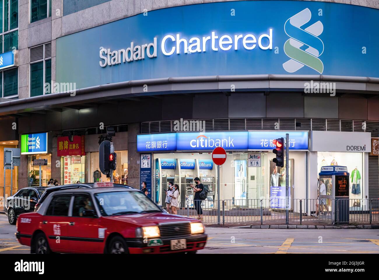 Cars Drive Past The British Multinational Banking And Financial Company Standard Chartered 