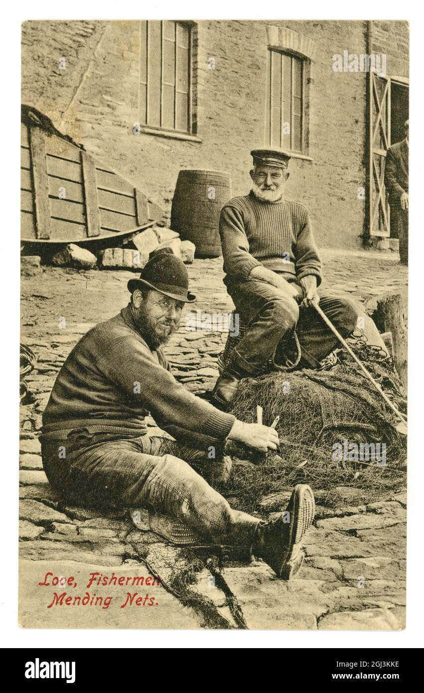 Original early 1900's real photographic postcard Looe Fishermen Mending Nets posted 7 October 1912, Cornwall Stock Photo