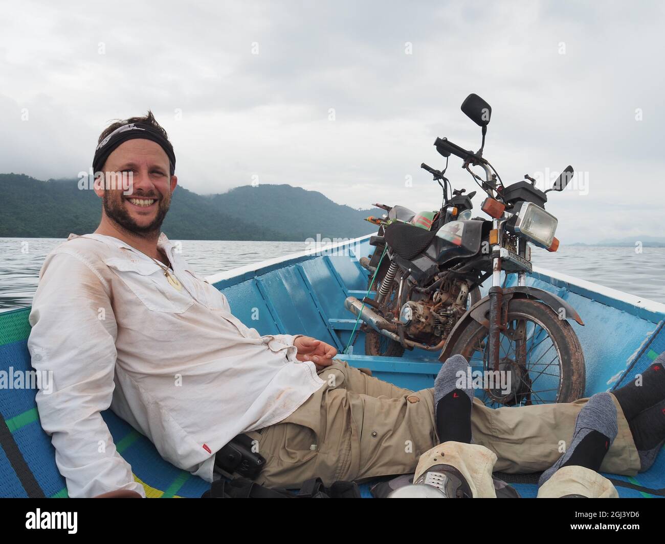 Shot of a Caucasian man enjoying a boat ride in a sea on gloomy weather in Spain Stock Photo