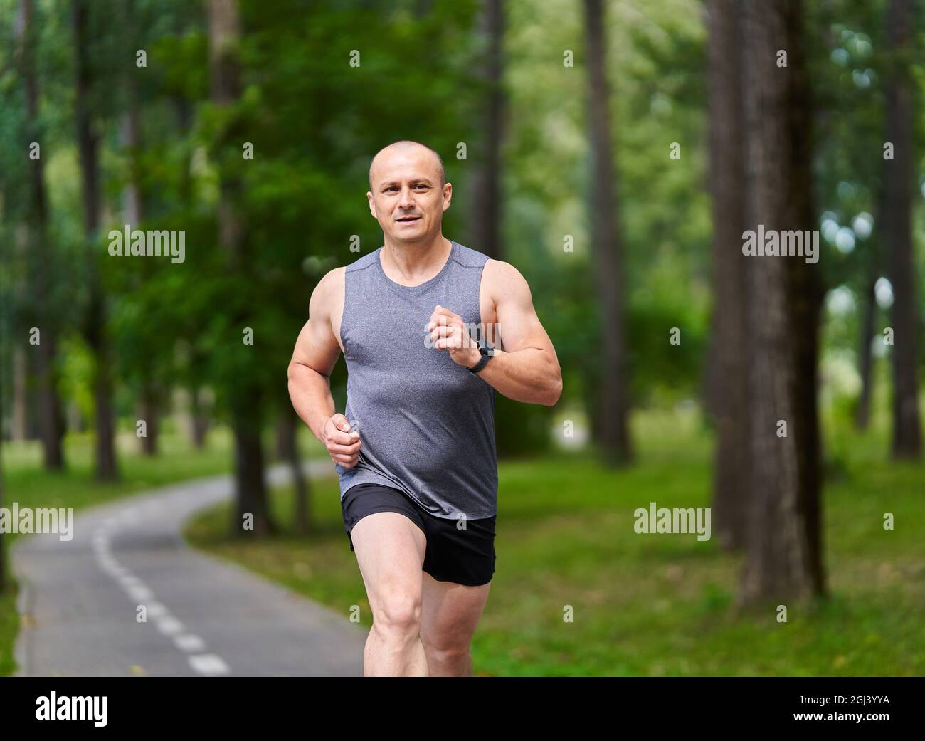 Athletic man long distance runner training in the park alleys Stock ...
