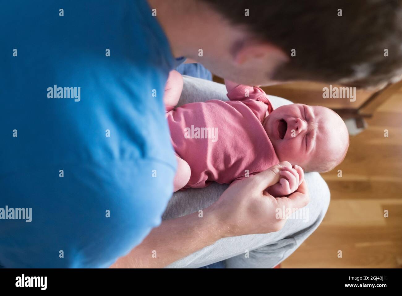 Little crying caucasian newborn baby suffering from colic pain Stock Photo