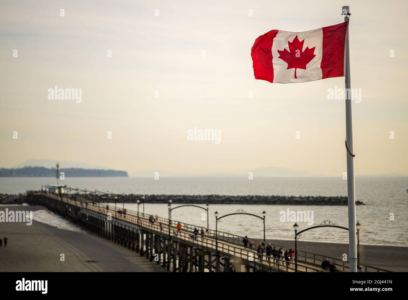 White Rock city pier in the dusk with flying Flag of Canada, British Columbia, Canada. Stock Photo