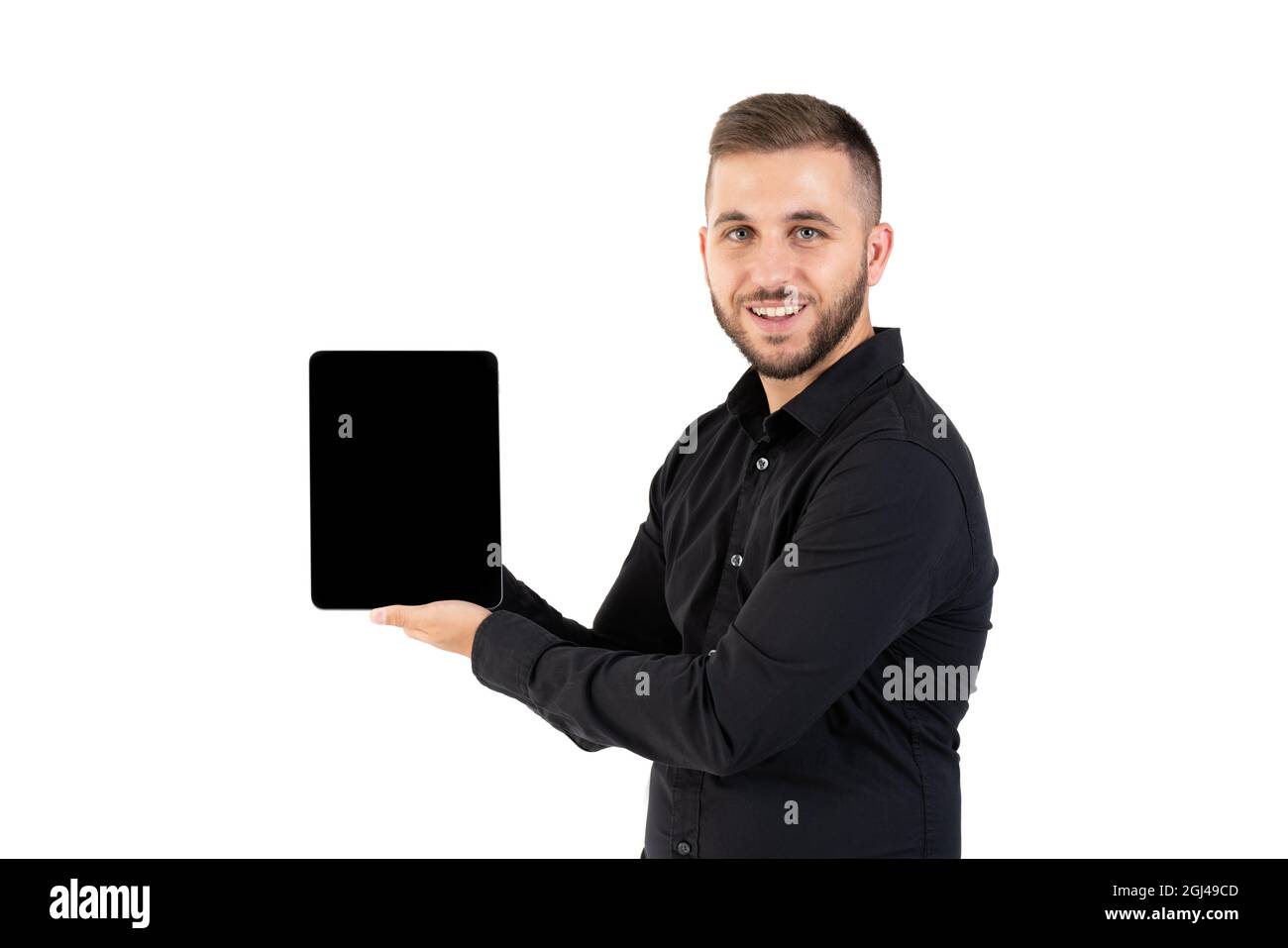 Young man with a black shirt showing a black screen tablet on a white background Stock Photo