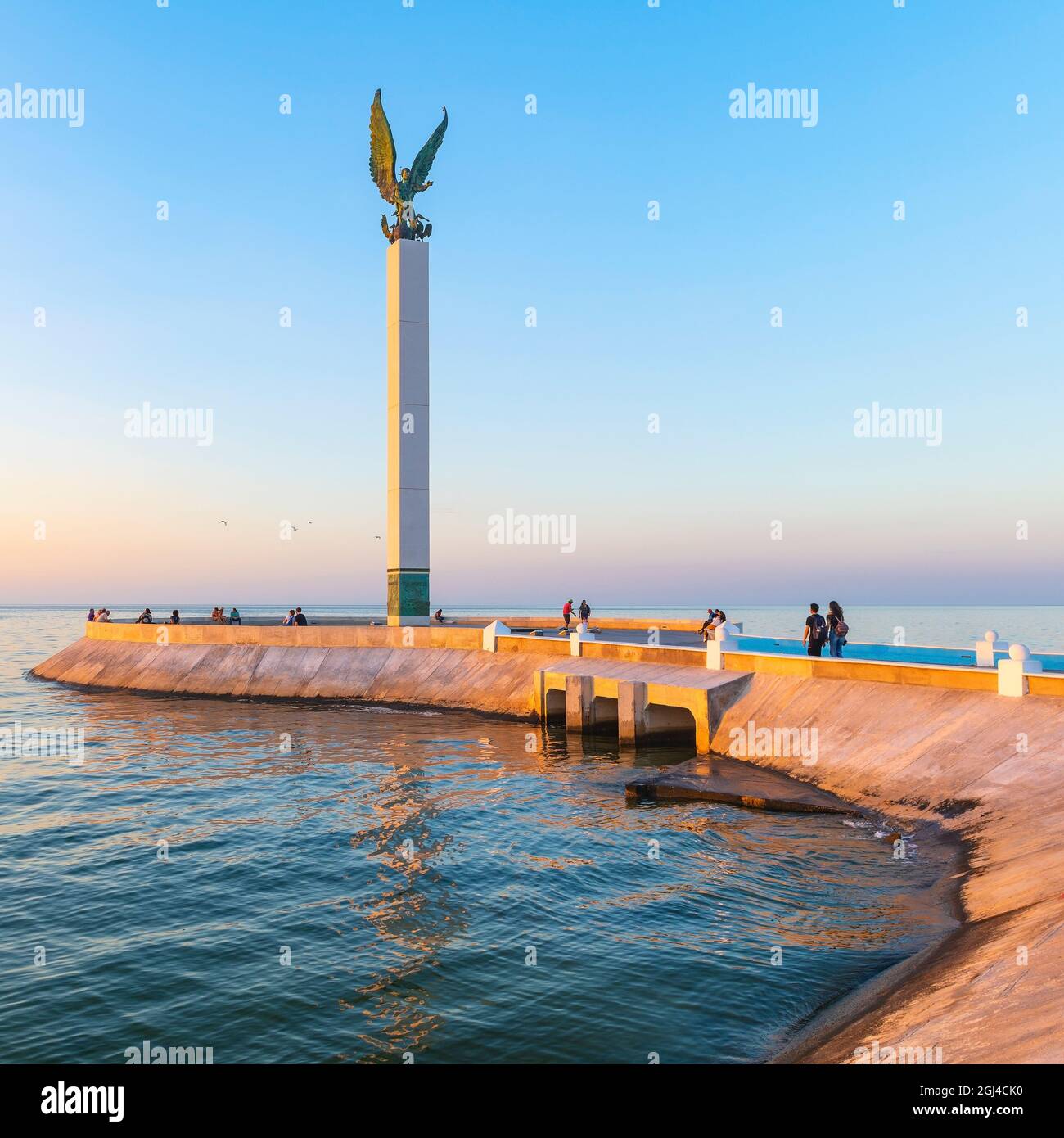 Pier or Malecon of Campeche at sunset with waterfront promenade and people by the Gulf of Mexico. Statue Maya World by Jorge Marin. Stock Photo